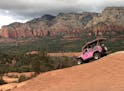 The Pink Jeep "Broken Arrow" tour begins its descent down the red rocks in Coconino National Forest.