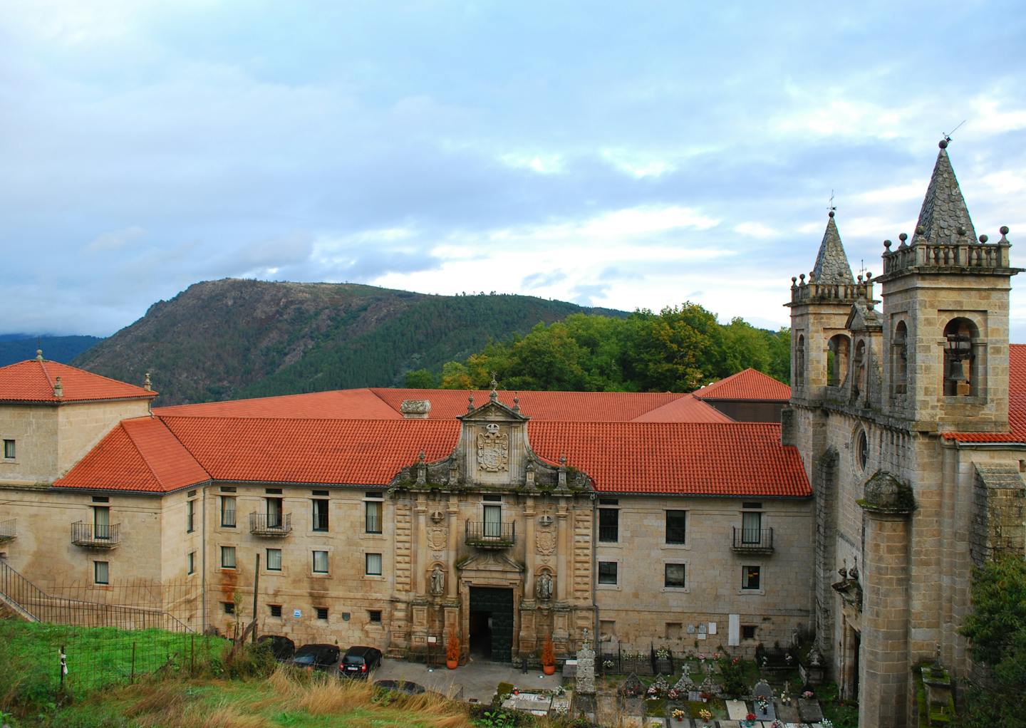 A forest surrounds the Parador de Santo Estevo, a former monastery in the Galician region of Spain. The sprawling complex shows off Romanesque, Gothic and Renaissance details.