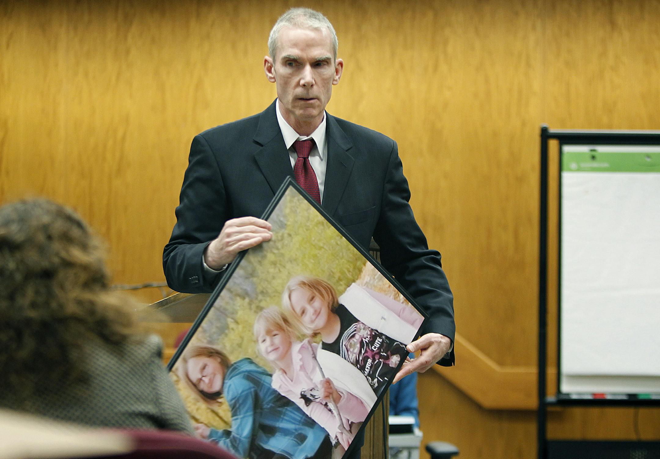 Prosecutor Gary Freyberg held a photo of the three children killed by Aaron Schaffhausen last summer in their Wisconsin home.