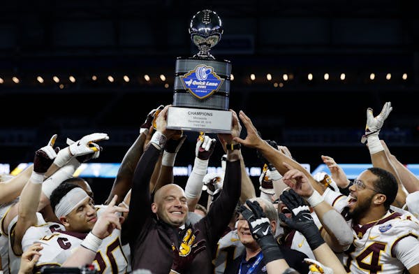 Football coach P.J. Fleck held up the champions trophy after the Gophers crushed Georgia Tech 34-10 in the Quick Lane Bowl in December.