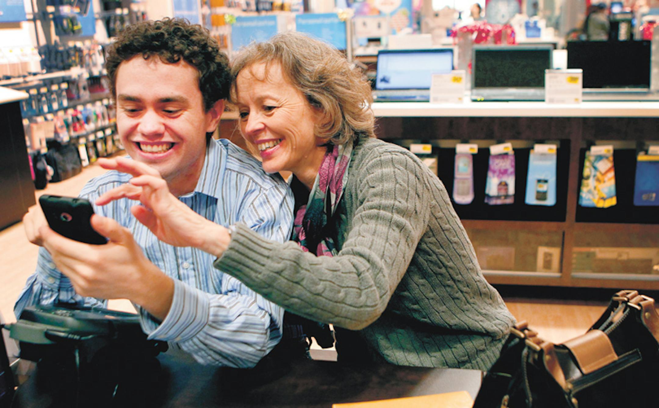 Brian Wille, 20, and his mother, Mary Wille, of Rochester, looked at a picture of themselves on Brian's new phone at the checkout counter of the Best Buy Mobile store at the Mall of America on Tuesday. The retailer is counting on big things from Best Buy Mobile.