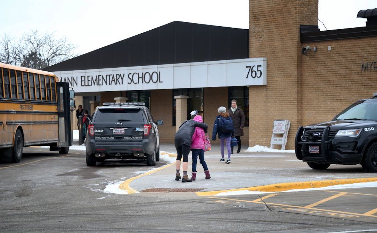 Meghan Stephenson hugs her child before staying goodbye outside Orono Schumann Elementary School as a police officer stands nearby as students arrive for the day Thursday, Feb. 22, 2018, a day after a threat was posted, causing Orono schools to go on lockdown. A student was arrested at the high school Wednesday after a threat of gun violence. Stephenson said she has children in all four of Orono's schools and she praised for how they dealt with the threat.