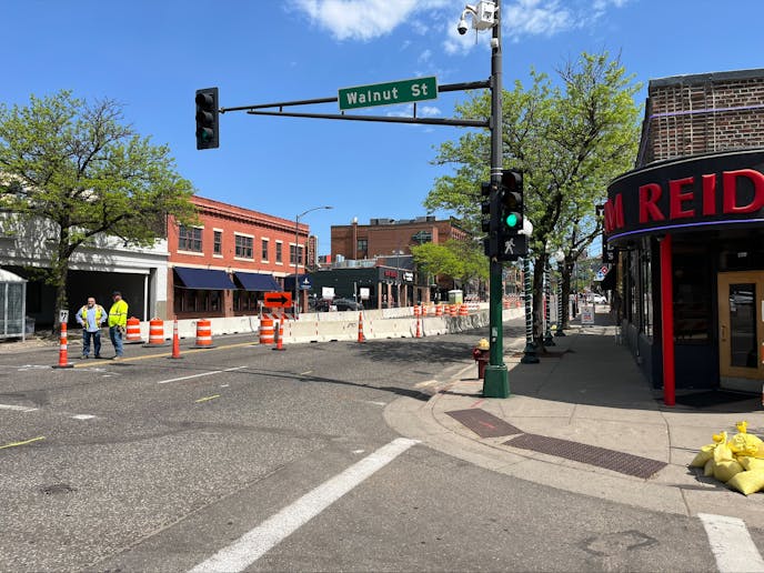 Crews stand along West Seventh Street in St. Paul, where a sinkhole opened. Construction could shut down regular traffic to the area for months.