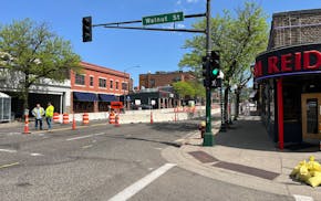 Crews stand along West Seventh Street in St. Paul, where a sinkhole opened. Construction could shut down regular traffic to the area for months.