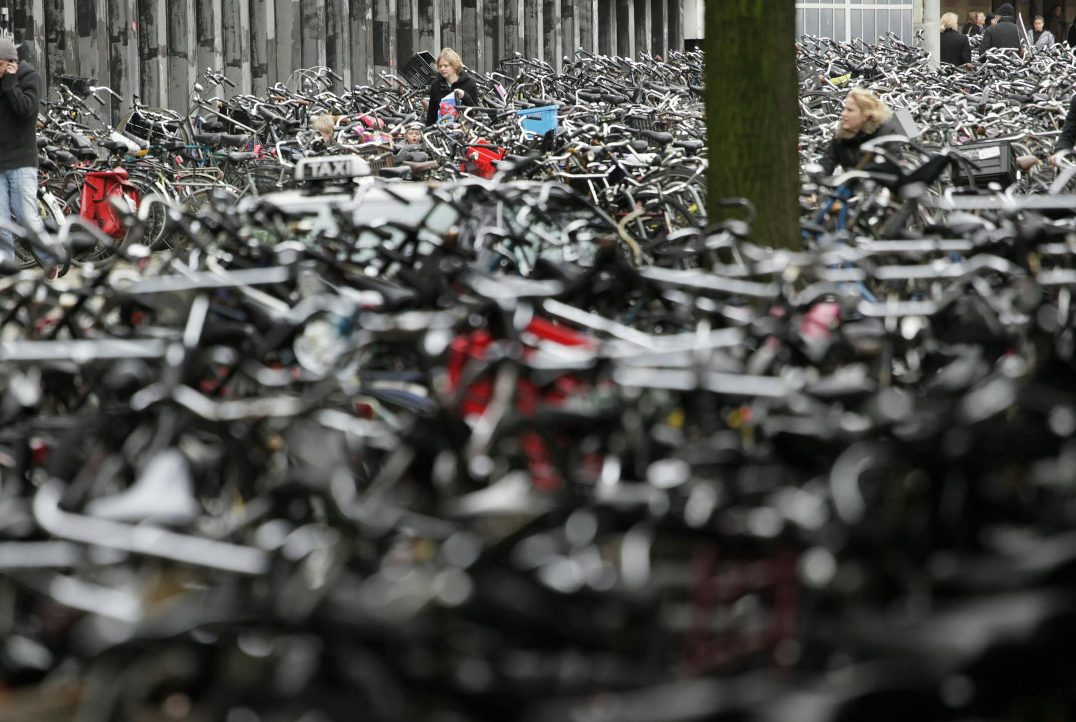Commuters make their way through thousands of parked bicycles outside Central Station in Amsterdam, Wednesday Jan. 19, 2011. (AP Photo/Peter Dejong)