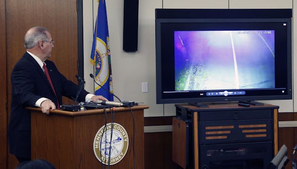 County Attorney Mike Freeman, shows video from evidence after he announced Wednesday, March 30, 2016, that no charges will be filed against two Minnea