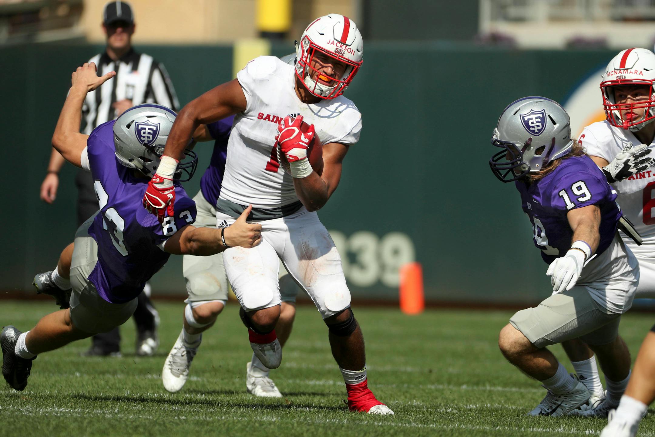 St. John's University wide receiver Joey Eckhoff (1) ran the ball as University of St. Thomas tight end Zach Bennett (83) reached out to grab him in the first half.