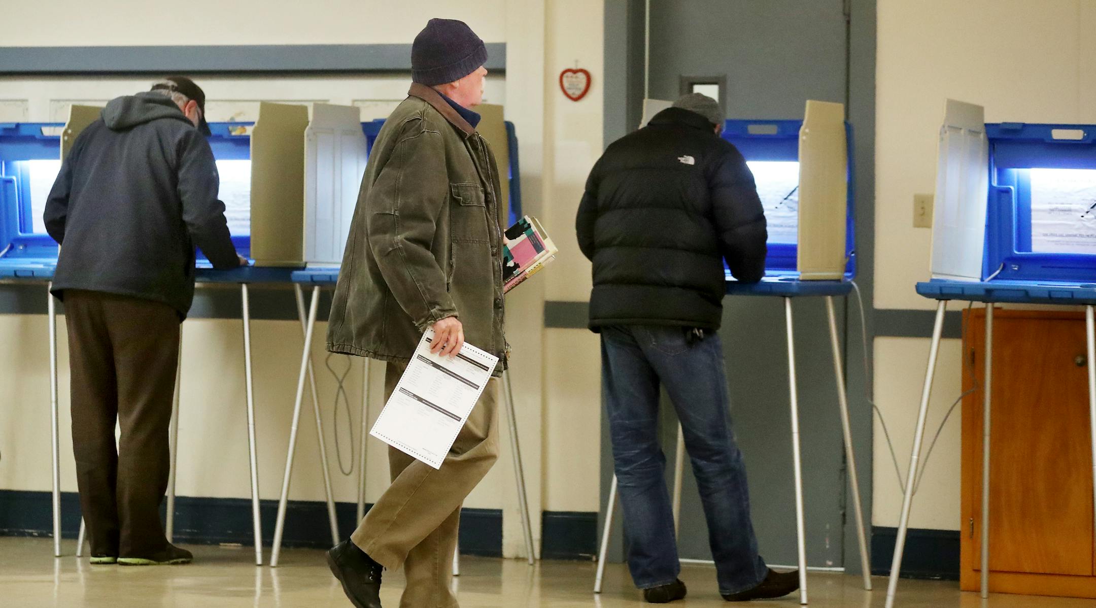 Jim Neumann, center, who recently moved to Minneapolis from Duluth, walks to a voting booth to cast his ballot as Brady Hegberg, left, and Abdalla Hilowle, right, vote at Norwegian Lutheran Memorial Church, also known as Mindekirken Tuesday, Nov. 7, 2017, in Minneapolis, MN.] DAVID JOLES ï david.joles@startribune.com Story about turnout on Election Day**Jim Neumann, Brady Hegberg, Abdalla Hilowle, cq