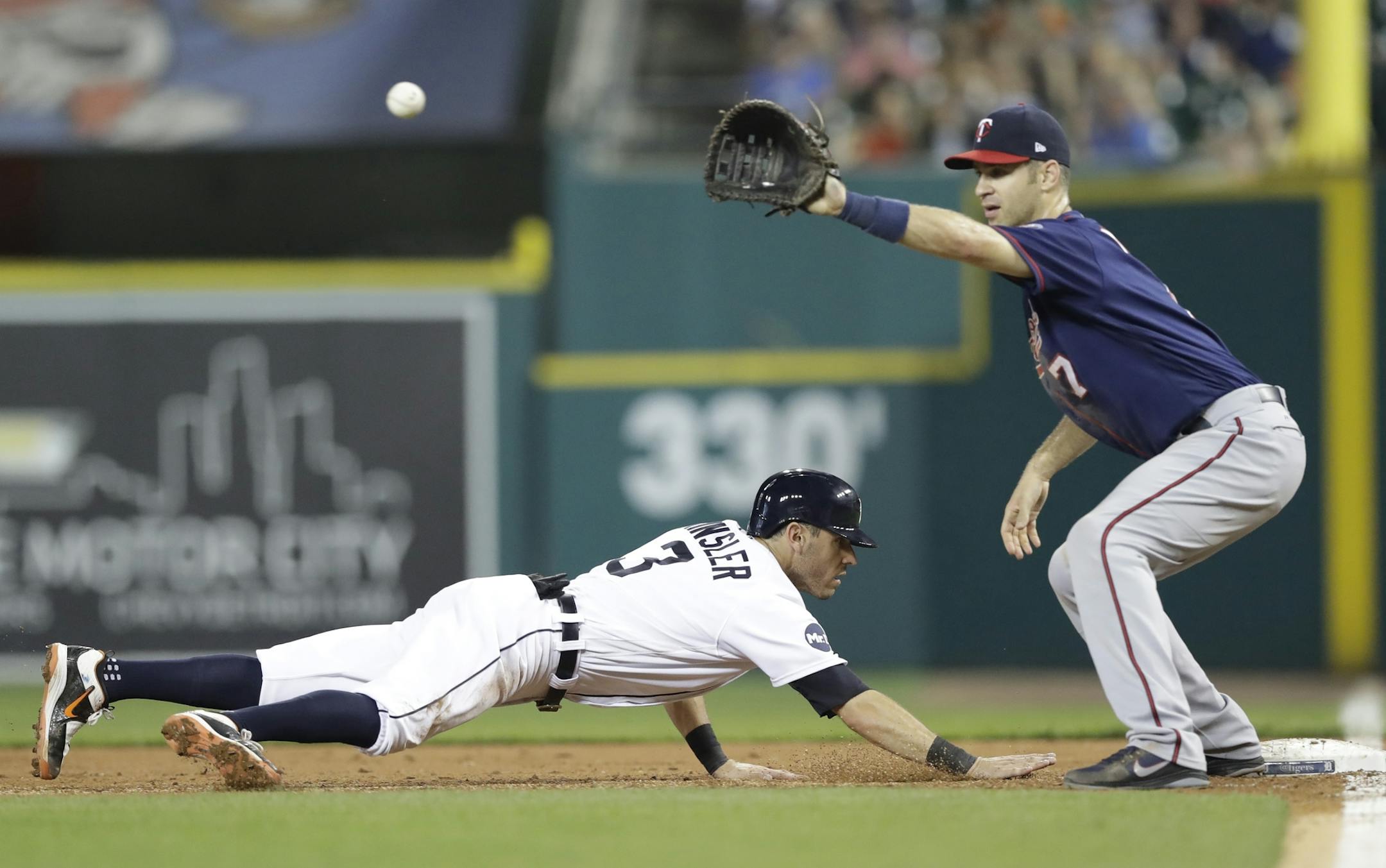 Detroit Tigers' Ian Kinsler safely jumps back as Minnesota Twins first baseman Joe Mauer waits on the pick off throw attempt during the third inning of a baseball game, Friday, Sept. 22, 2017, in Detroit. (AP Photo/Carlos Osorio)