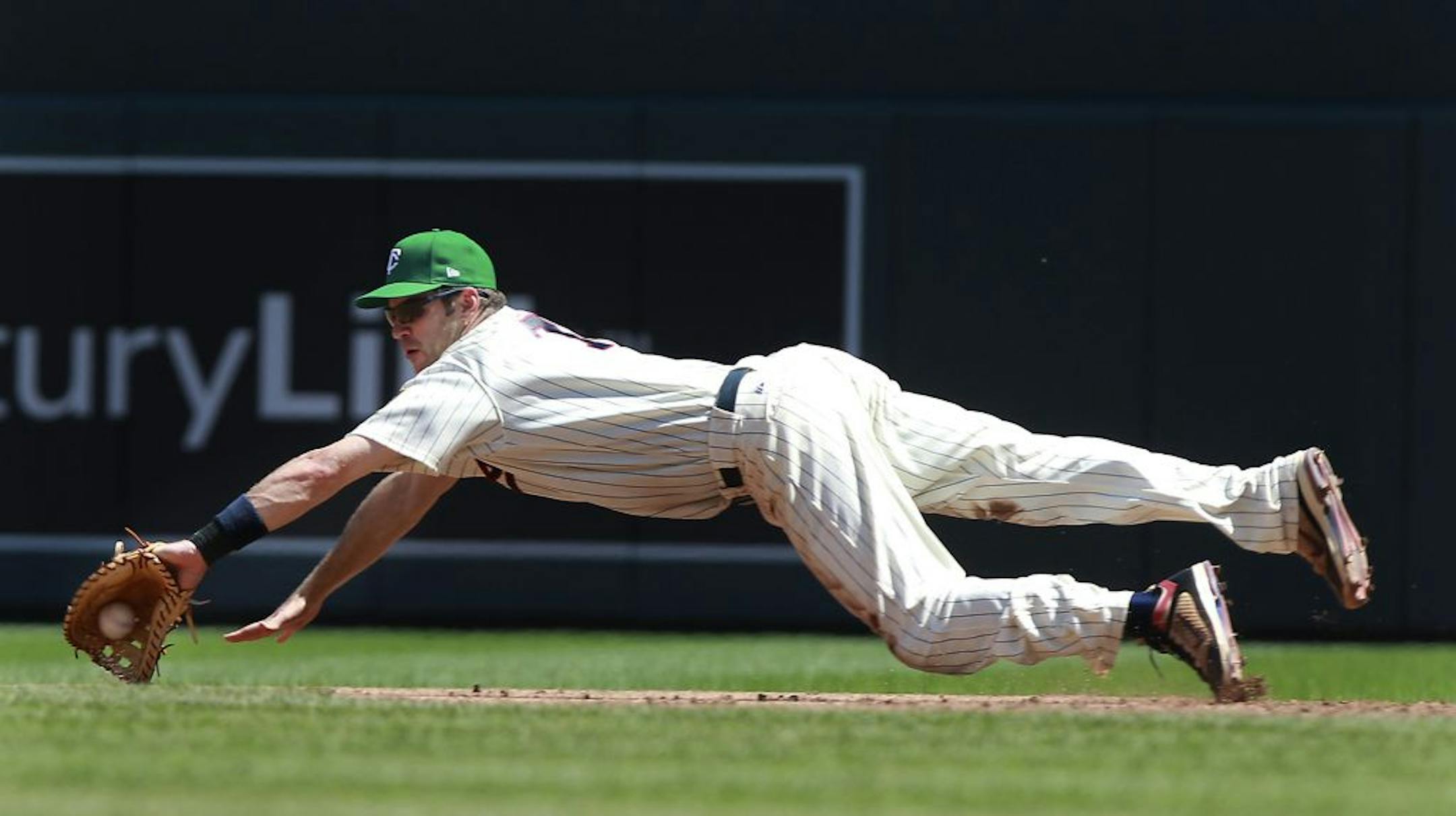 The Twins' Joe Mauer went for a ball Monday while covering first base during the top of the ninth inning against the Indians.