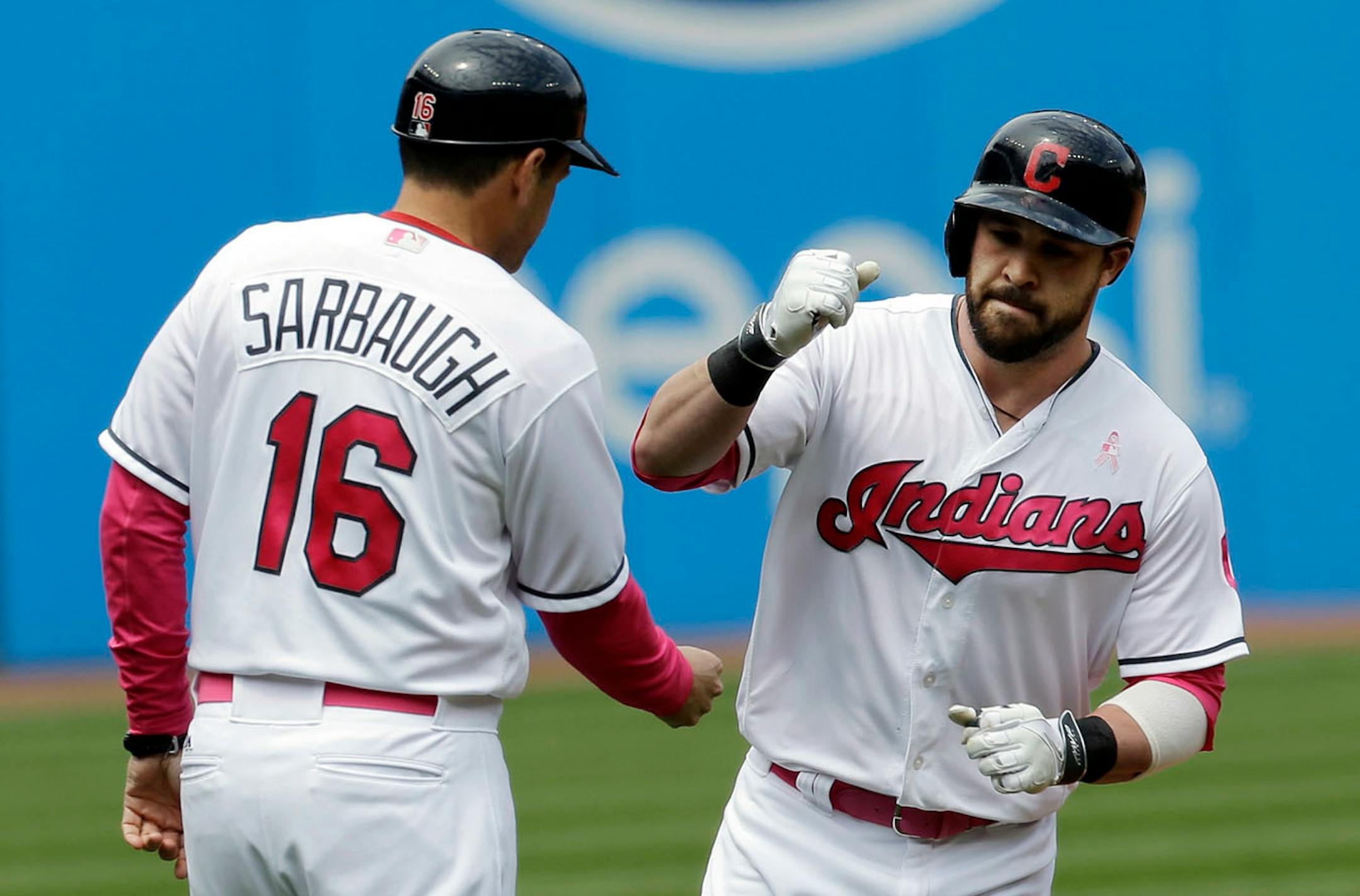 Cleveland Indians' Jason Kipnis, right, is congratulated by third base coach Mike Sarbaugh after hitting a solo home run off Minnesota Twins' Hector Santiago in the first inning of a baseball game, Sunday, May 14, 2017, in Cleveland.