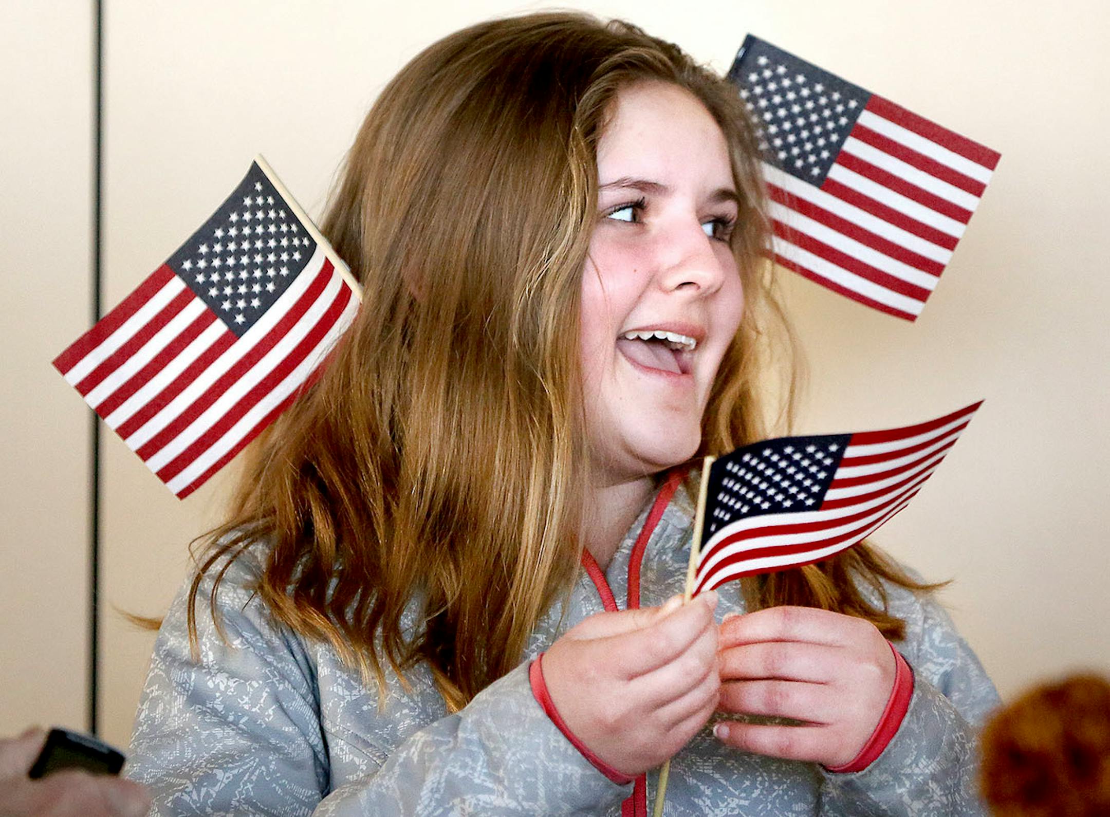 Kaitlin Traylor, 13, of Duluth, gets in the American spirit while waiting for the Duluth curling team to arrive at the airport Monday evening. Bob King / rking@duluthnews.com