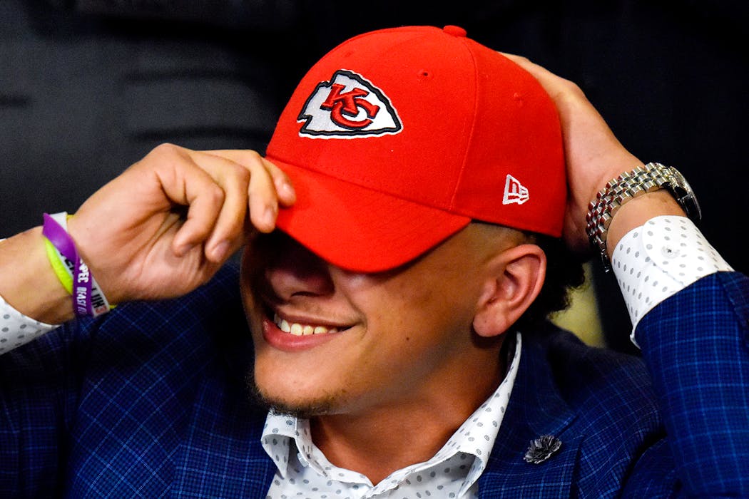 Patrick Mahomes II smiles as he puts on a Kansas City Chiefs hat during an NFL football draft watch party in Tyler, Texas