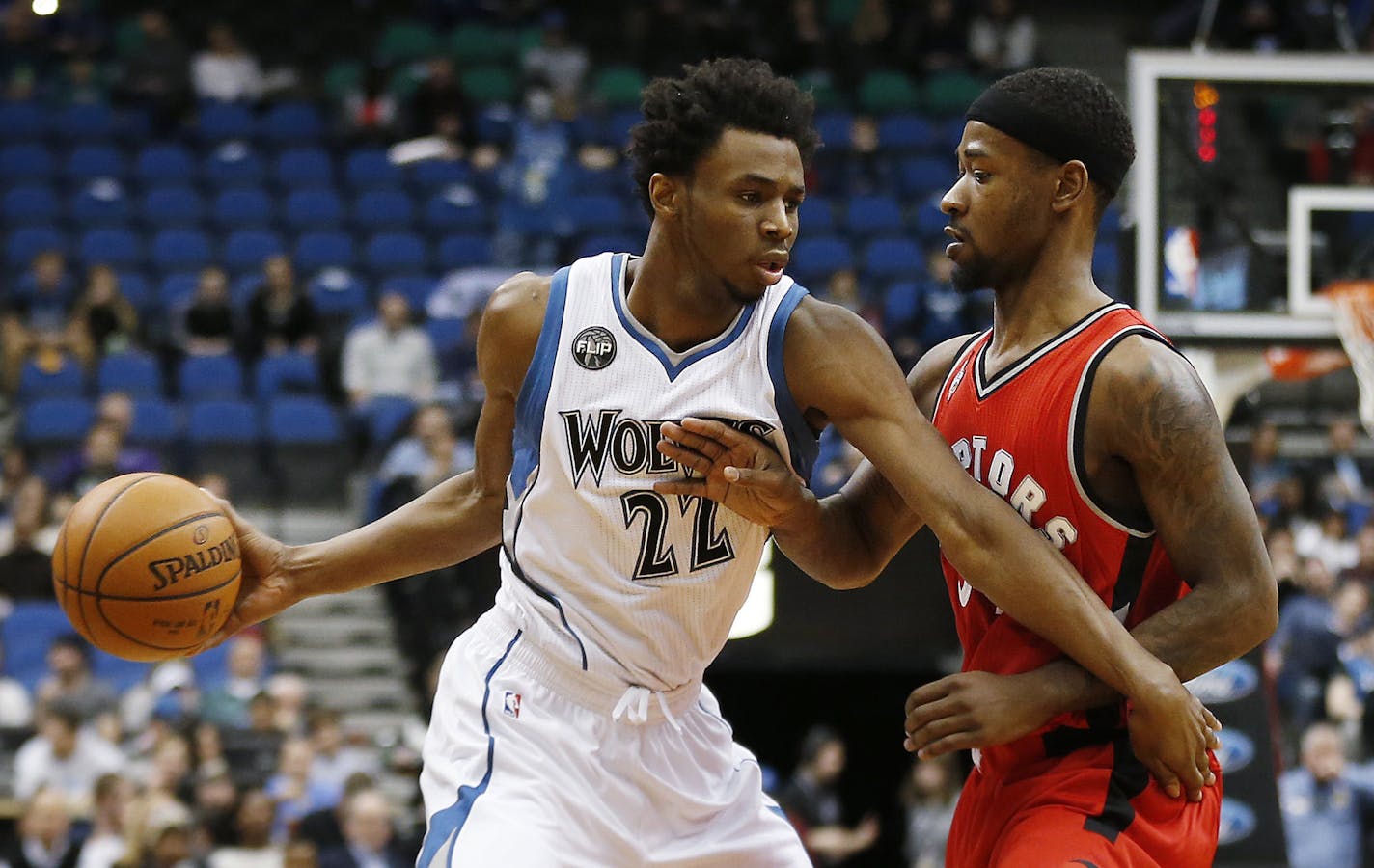 Minnesota Timberwolves forward Andrew Wiggins (22) pushes the ball around Toronto Raptors guard Terrence Ross (31) in the first half of an NBA basketball game Wednesday, Feb. 10, 2016, in Minneapolis. (AP Photo/Stacy Bengs)