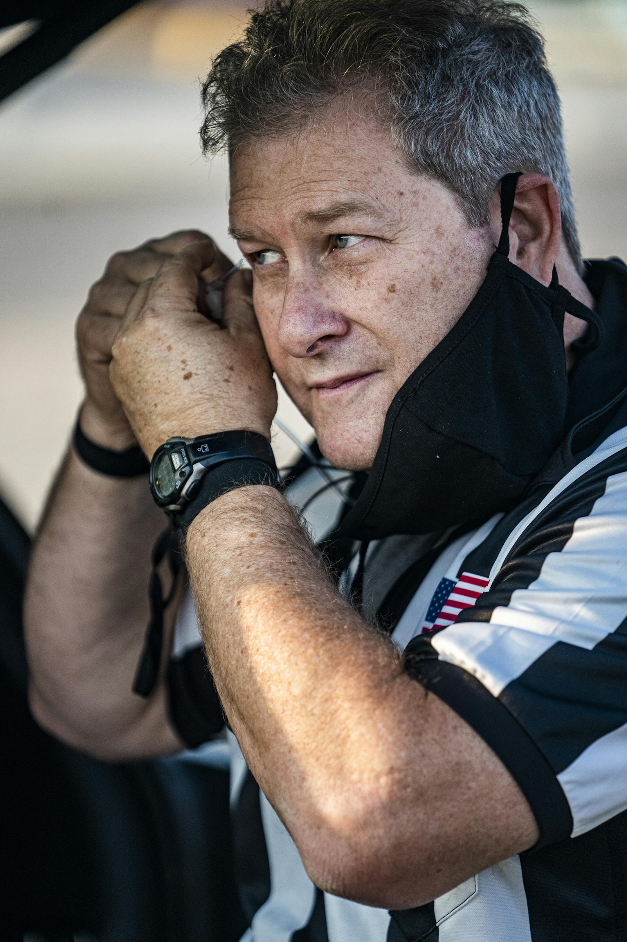 Umpire Brian Grandstand adjusts the helmet of a player during the game between Hopkins and Apple Valley.