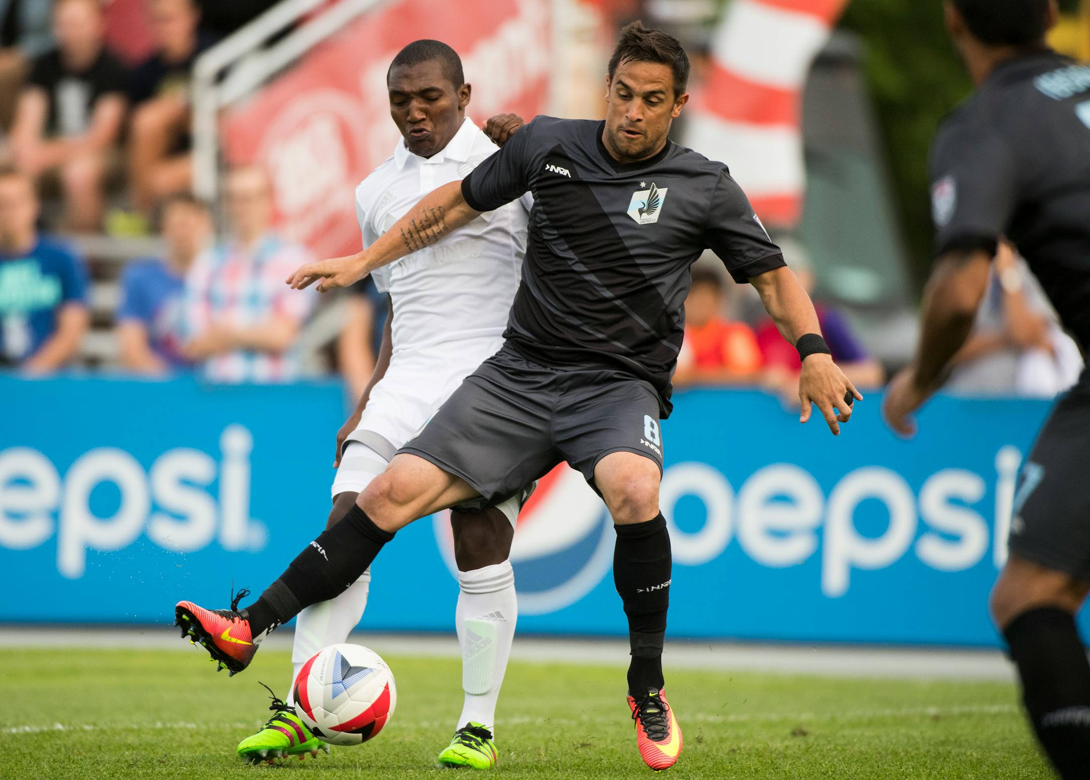 Minnesota United FC forward Danny Cruz (8) fends off Sporting Kansas City midfielder Jimmy Medranda (94) as he attempts to keep possession of the ball in the first half. ] Isaac Hale � isaac.hale@startribune.com Minnesota United took on Sporting Kansas City in Blaine, MN, at National Sports Center on Wednesday, June 15, 2016.