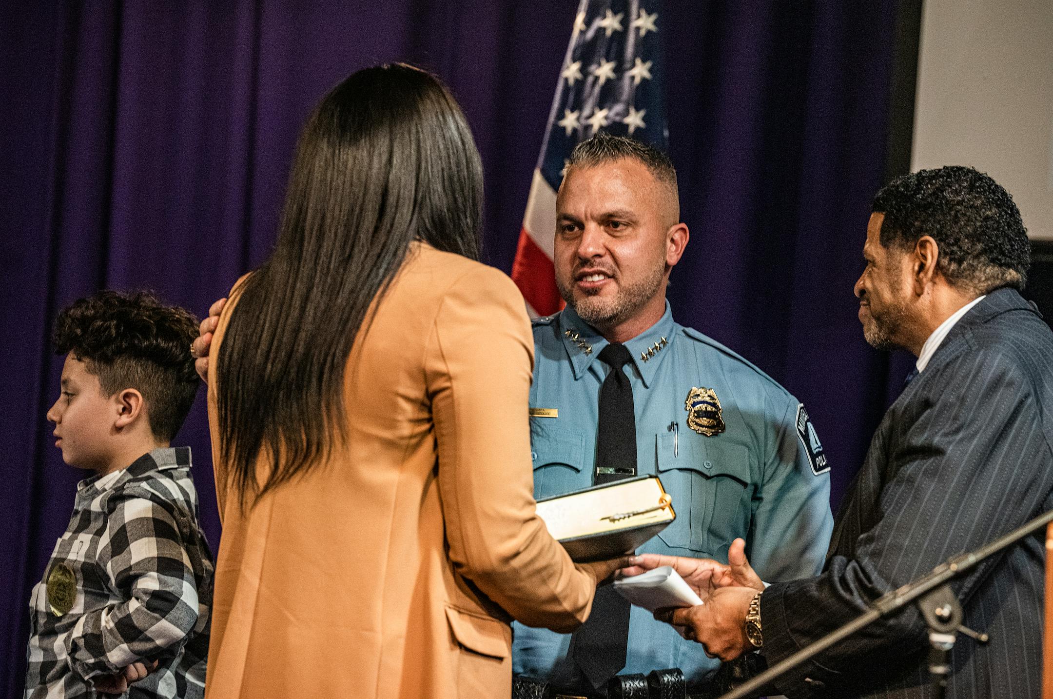 Bishop Howell Jr. presides as Brian O'Hara is sworn in as the new Minneapolis Chief of Police surrounded by wife Wafiyyah O'Hara and son Brendan, 11.