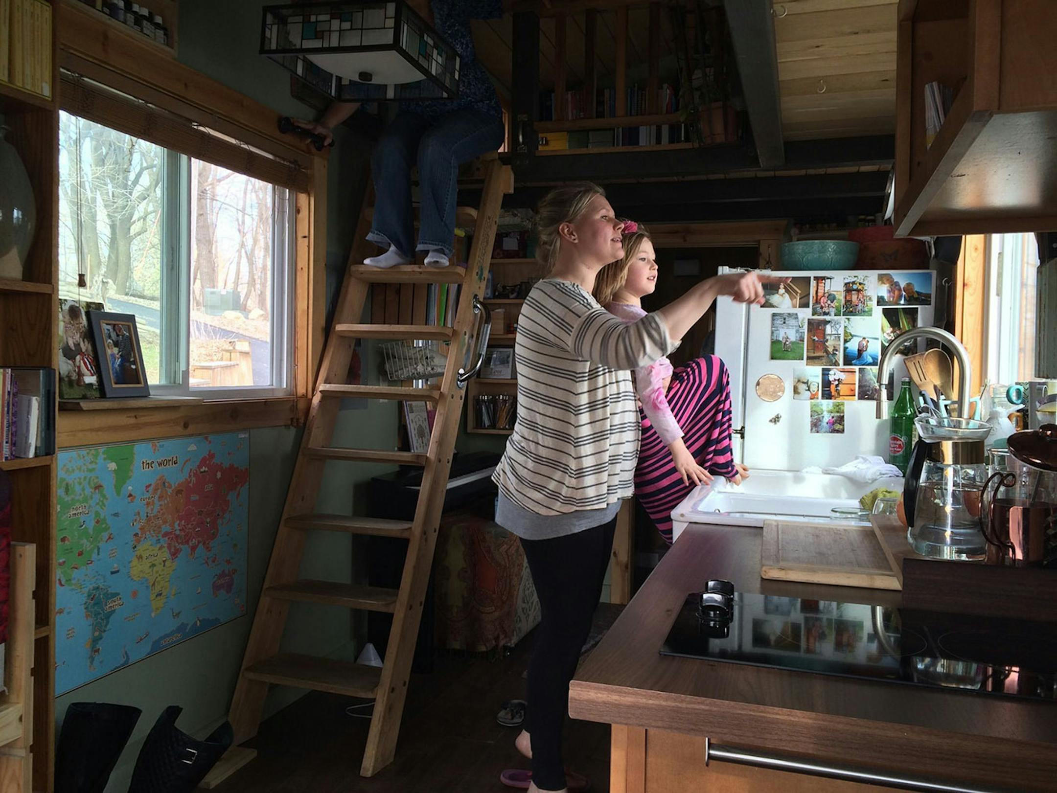 Kim Kasl, with Story, 6, points to something outside the kitchen window of their tiny house.