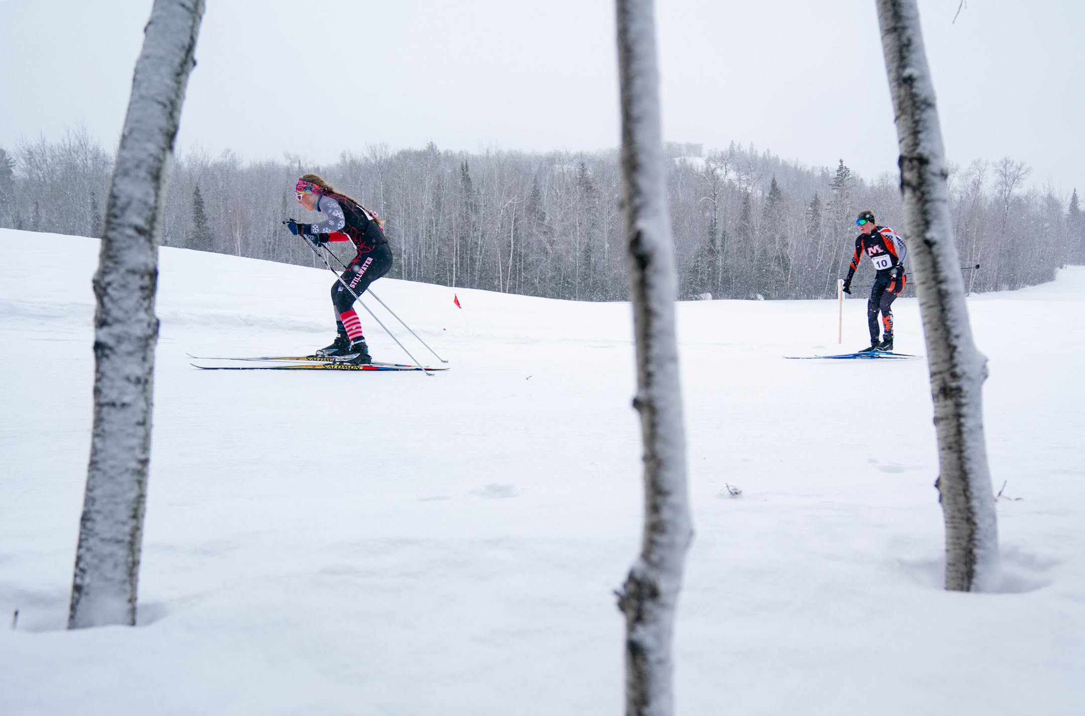 Stillwater Area nordic skier Jocelyn McBride (14) maintains a narrow lead over Moorhead's Jacki Johnson (10) in the girl's team spring qualification race during the MSHSL Boys and Girls Nordic Ski Racing Meet.