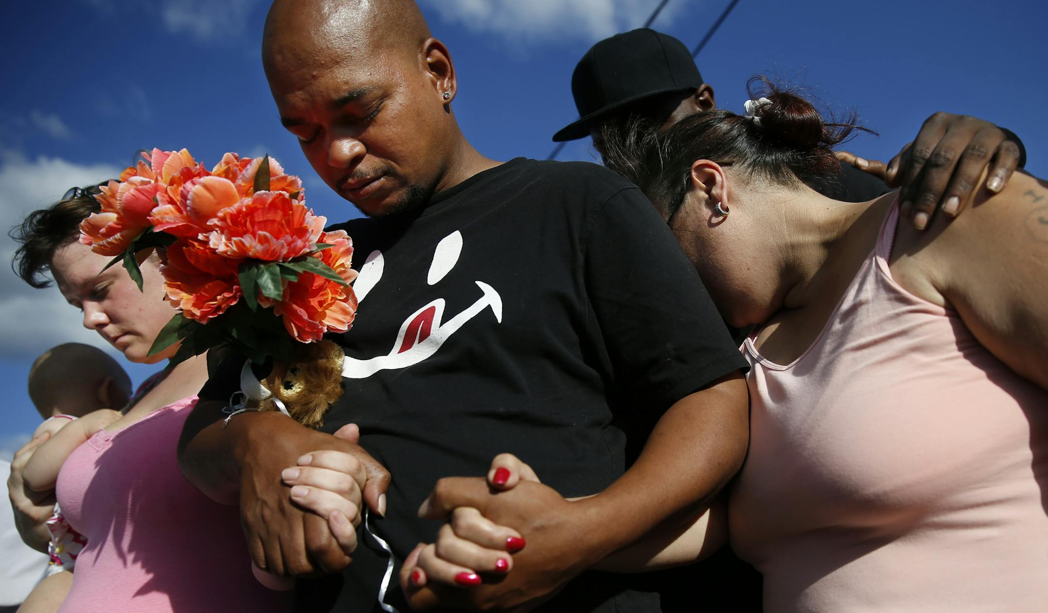 At a vigil for Arnong Rajvong near 26th and Washington Ave N. where she was killed on Saturday, left to right, Brittany Hunt, holding daughter Bella, husband Benjamin King, and Julia Icemen were relatives who grieved for the loss of the 26-year old relative. ] tsong-taataarii@startribune.com