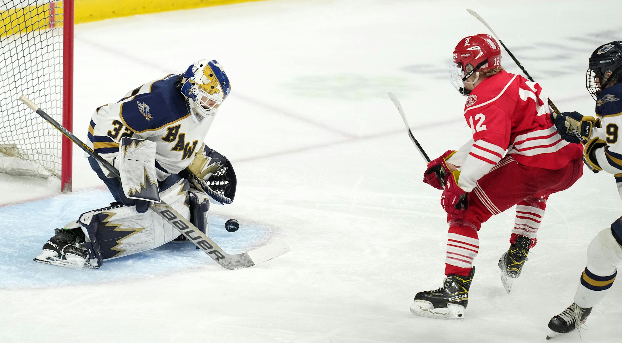 Luverne forward Elliot Domagala (12) takes a shot on Hermantown goaltender Dane Callaway (32) in the second period of a MSHSL Class 1A quarterfinal hockey game between Luverne and Hermantown.