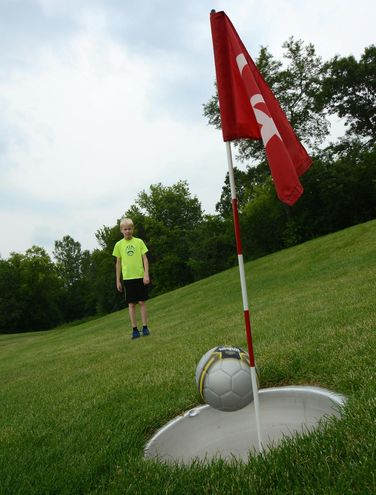 Anders Otness, 11, of Rosemount, kicked his ball into the cup during a round of footgolf at Inver Wood Golf Course in Inver Grove Heights.