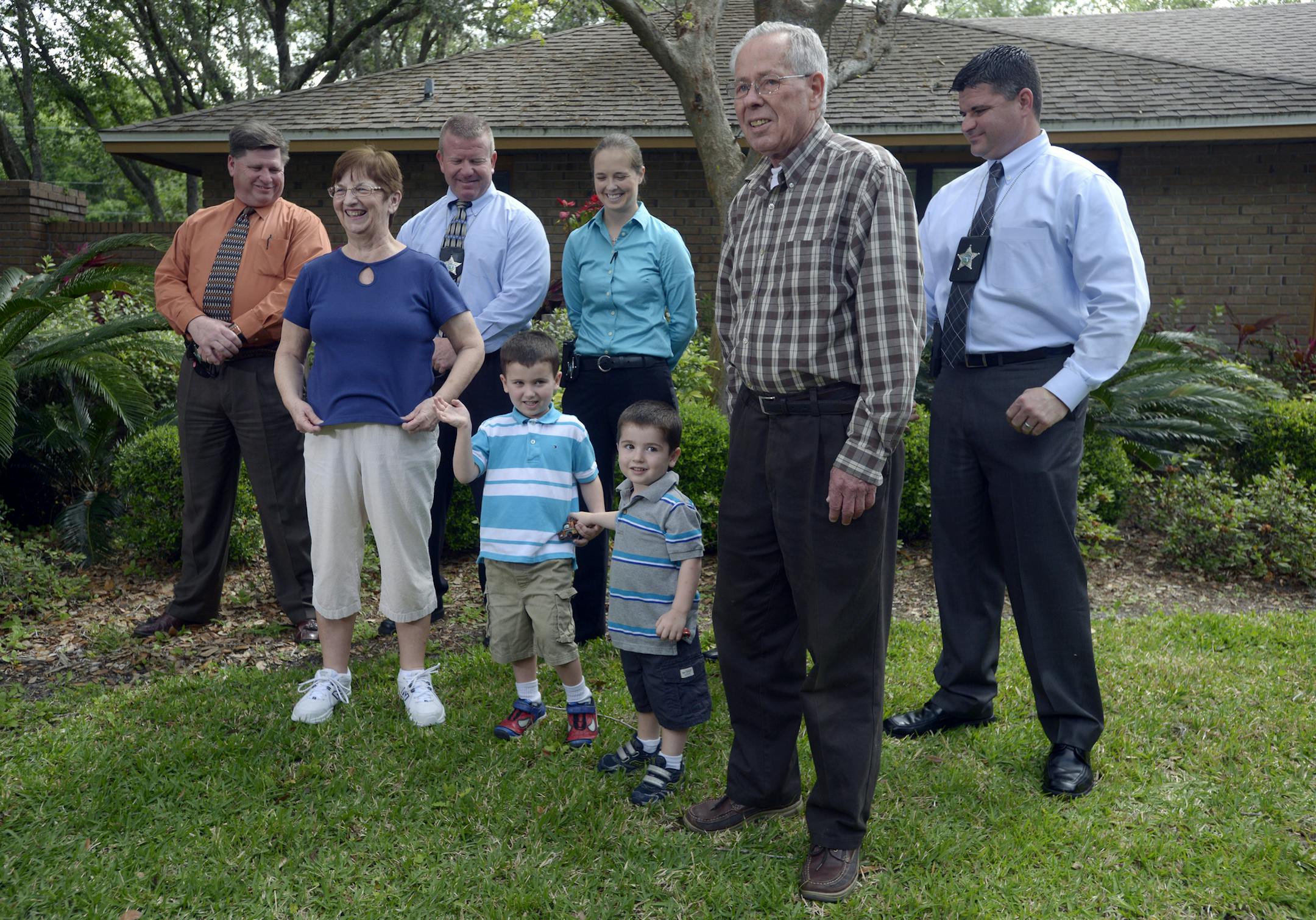 Patricia, front left, and Robert Hauser, front right, stand with their grandchildren, Cole Hakken, 4, second from left, and Chase, 2, with Hillsborough County Sherrif's investigators behind them, during a news conference outside the Hauser home in Tampa, Fla., Thursday, April 11, 2013. The two children were returned to the grandparents after their father, Joshua Hakken, forcibly kidnapped the children and sailed with them to Cuba. (AP Photo/Phelan M. Ebenhack)