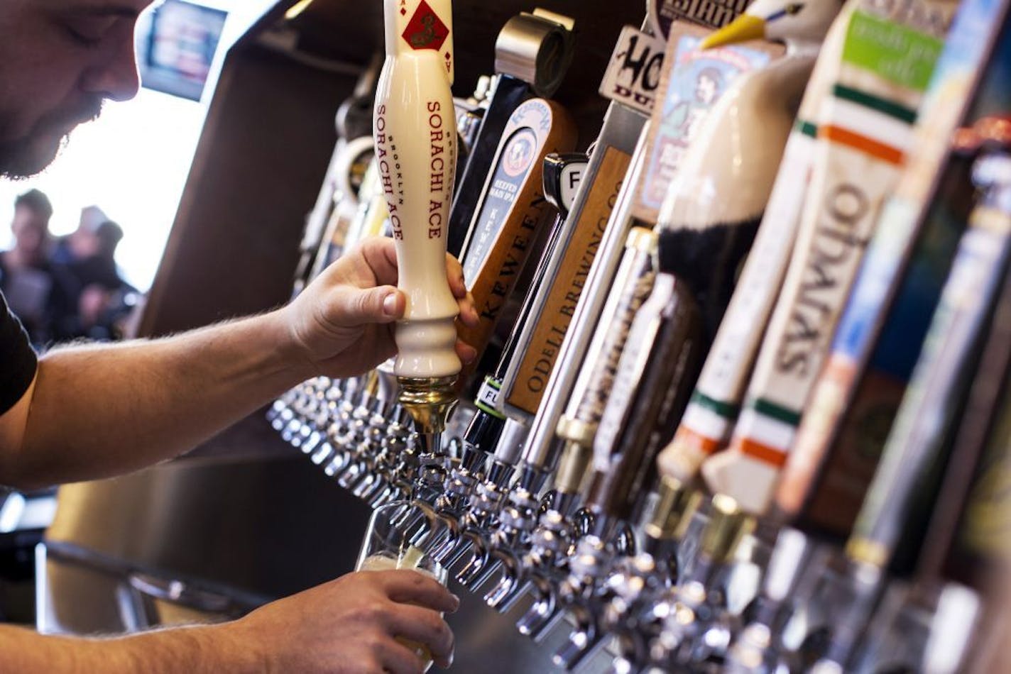 Eric Hellzen draws a beer from one of the 76 taps at The Happy Gnome in St. Paul March 15, 2014.