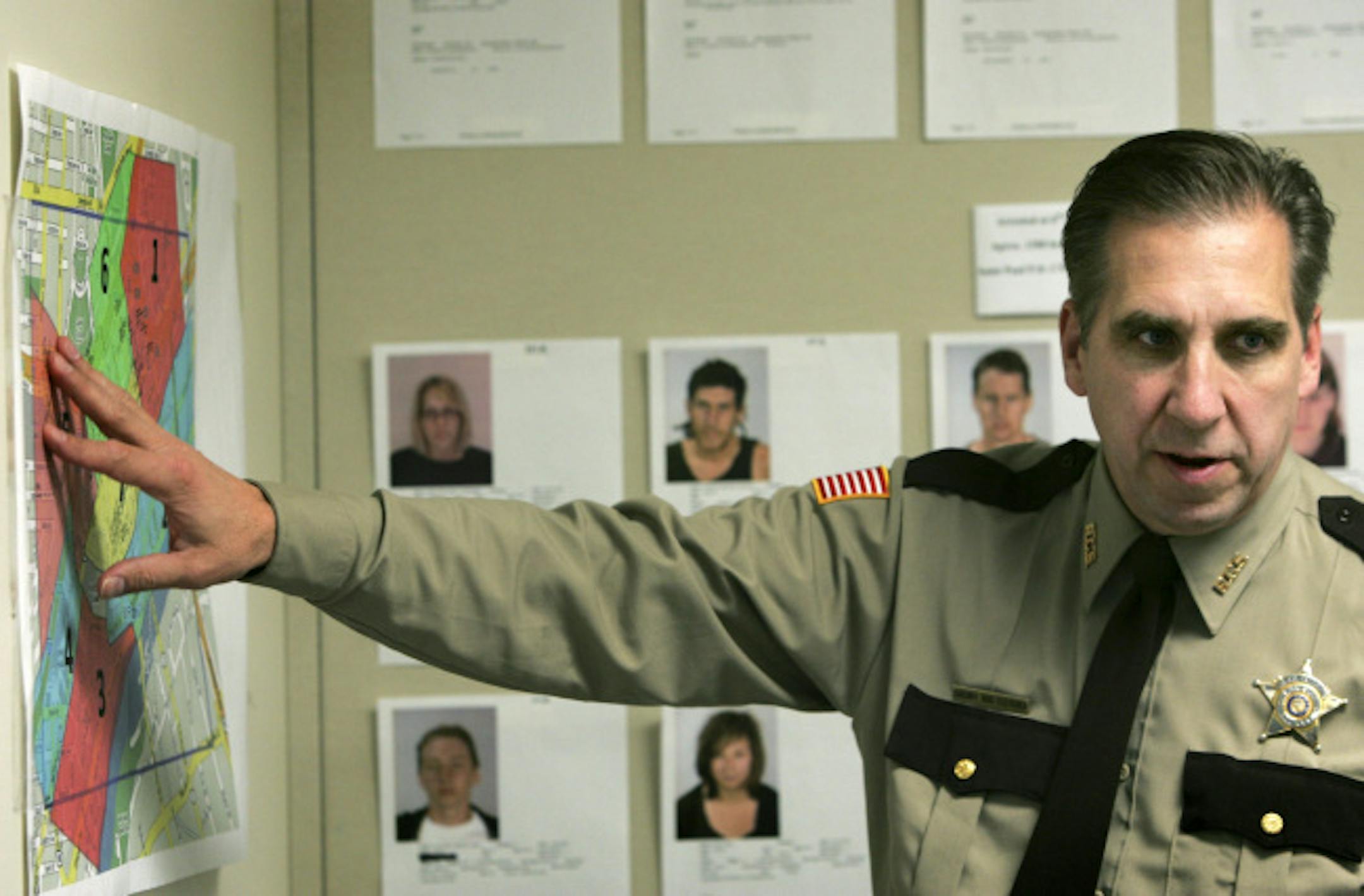 Ramsey County Sheriff Bob Fletcher talked about how the various Republican National Convention protest groups divided the area around the Xcel Center into sectors. Behind Fletcher are photographs of people arrested during the convention.