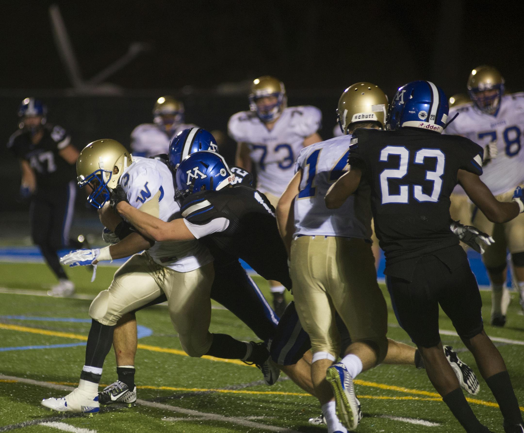 Wayzata's Anthony Clarke is brought down by Minnetonka's Braden Sikes but picks up a clutch first down in the process enabling Austin Gordon to carry it nearly 50 yards for a touchdown to give Wayzata a 31-28 lead with three minutes left. Wayzata went on to win 31-28 Friday, October 24, 2014 at Minnetonka High School. ] (Matthew Hintz, 102414, Minnetonka)