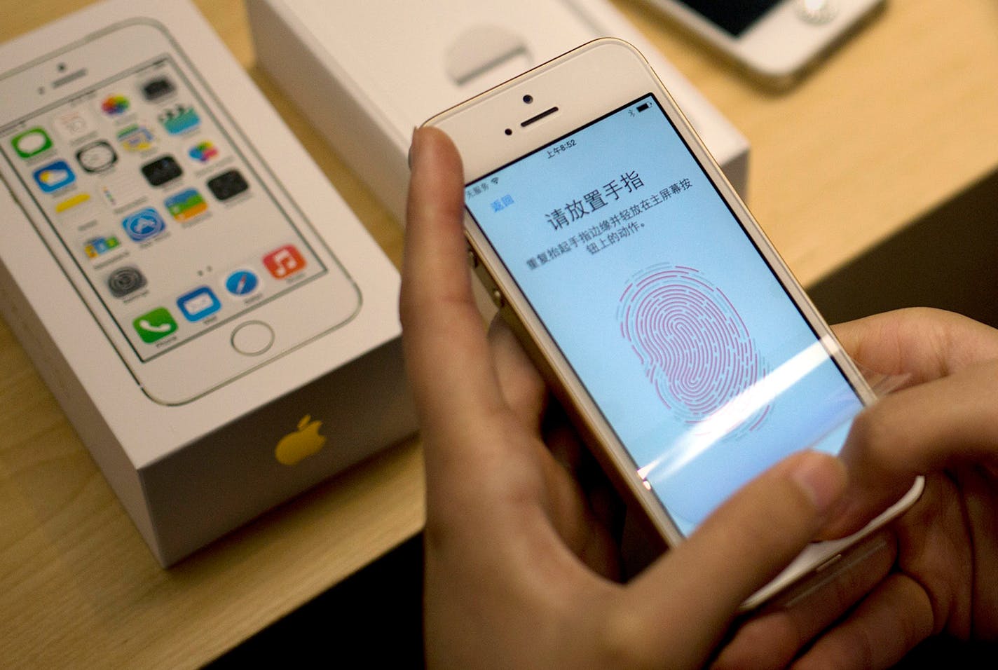 In this file photo, a customer configures the fingerprint scanner technology built into iPhone 5S at an Apple store.