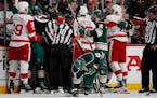 The Wild and Red Wings converge as Jared Spurgeon (46) tried to get up off the ice after taking a stick to the face in the first period