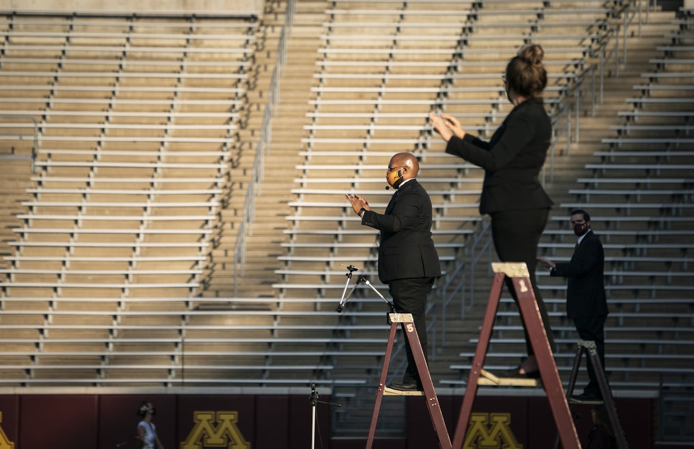 Marching band assistant director Lance Sample, left, conducted a recording of the marching band to be used during future games at TCF Bank Stadium in Minneapolis, Minn., on Thursday, October 8, 2020. ] RENEE JONES SCHNEIDER renee.jones@startribune.com Champlin Park vs. Centennial in Circle Pines, Minn., on Thursday, October 8, 2020.