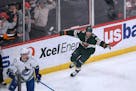 Minnesota Wild left wing Kevin Fiala, right, celebrates his goal as Vancouver Canucks defenseman Tyler Myers skates away during the second period of a