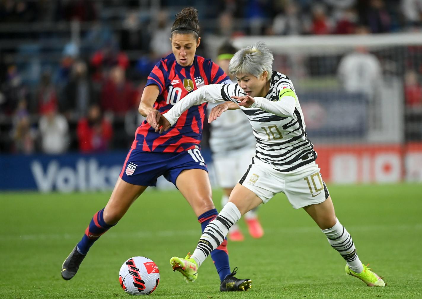 USWNT forward Carli Lloyd and South Korea midfielder Ji Soyun battle for the ball during the first half Tuesday