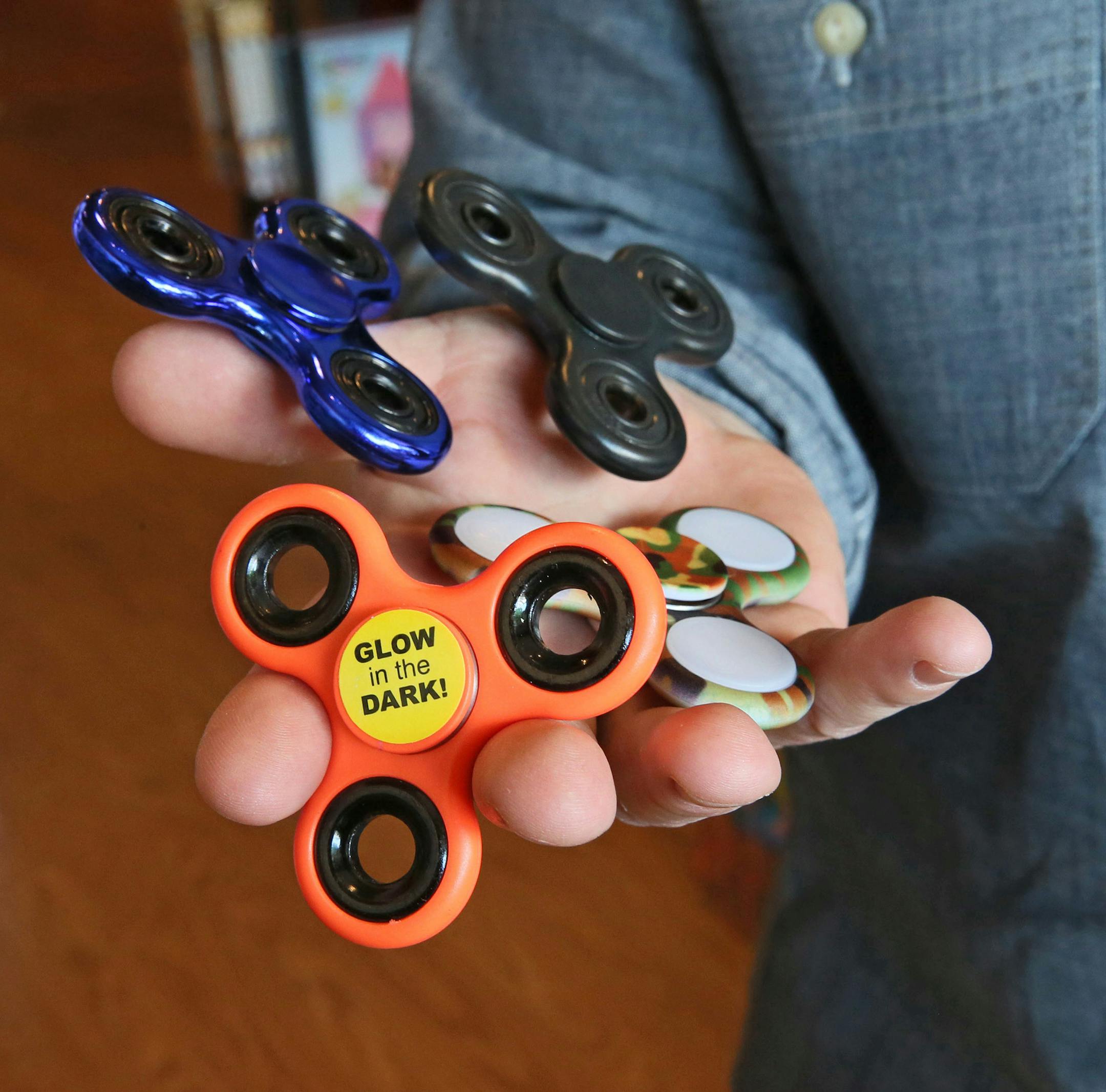 Matthew Poulson, co-owner of Ruckus & Glee in Wauwatosa shows the popular fidget spinners, which look like toys but are being used by adults as well, on Wednesday, May 31, 2017. They fit in your pocket and when you spin them they kind of calm you down. (Michael Sears/Milwaukee Journal Sentinel/TNS) ORG XMIT: 1203543