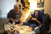 Dennis Prothero, 68, who is paralyzed from the neck down from an auto accident 18 years ago, gets ready for the day in his apartment with the help of 
