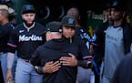 Luis Arraez, center, says his goodbyes in the Marlins dugout after being traded to the San Diego Padres before the team's game Friday.
