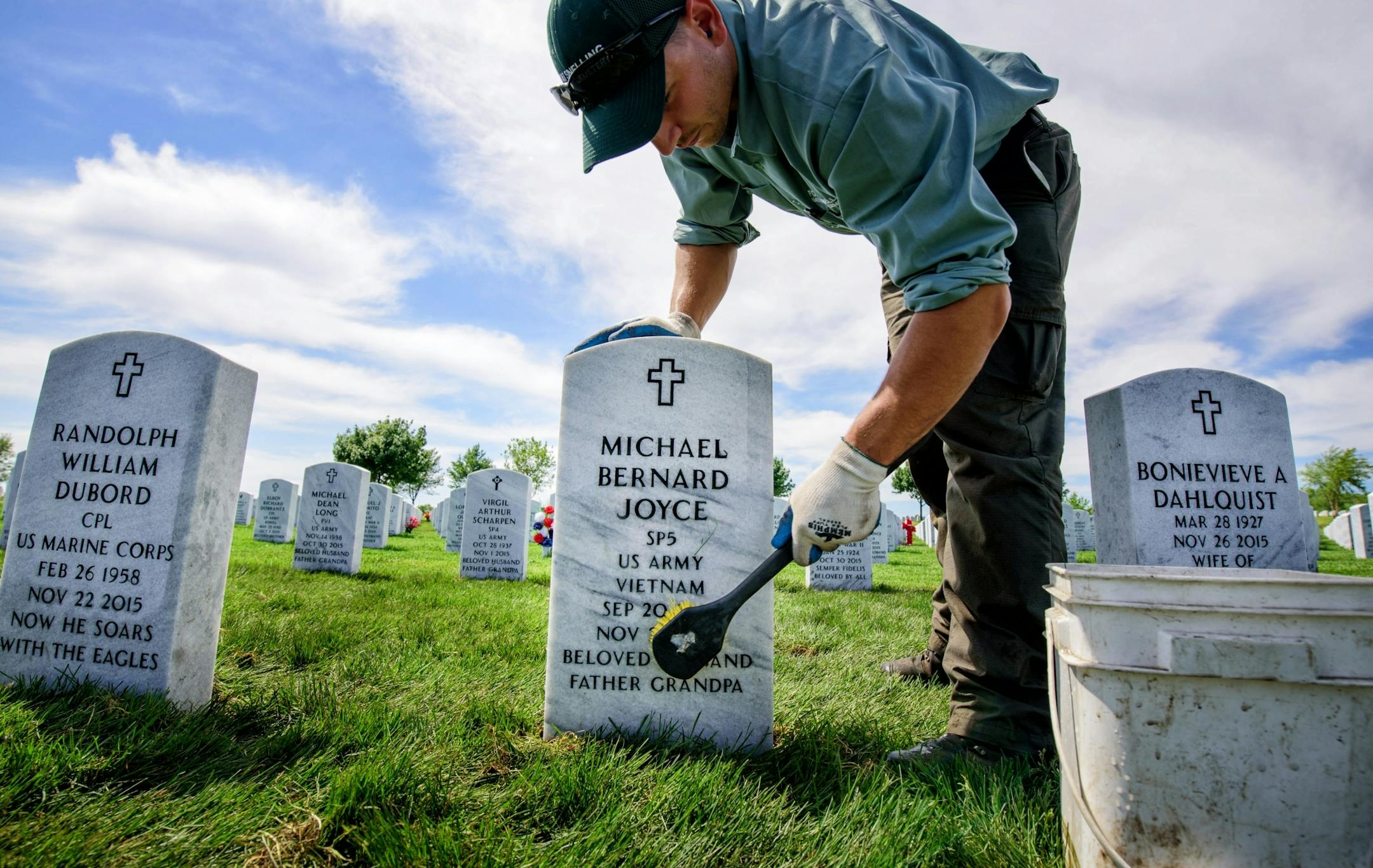 Joe Jandrich carefully hand scrubbed grave markers in a new section of Fort Snelling National Cemetery where fresh sod had just been installed.
