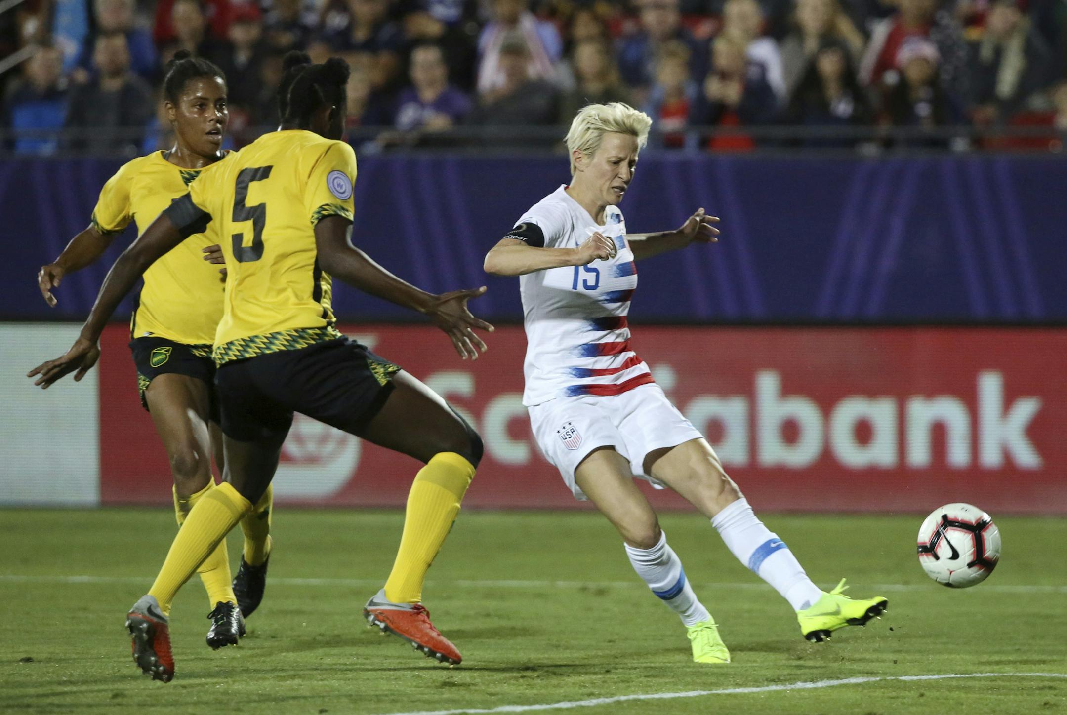 United States forward Megan Rapinoe scores a goal while being defended by Jamaica defender Konya Plummer during the first half of a CONCACAF women's World Cup qualifying tournament soccer match in Frisco, Texas on Oct. 14. The U.S. won 6-0.