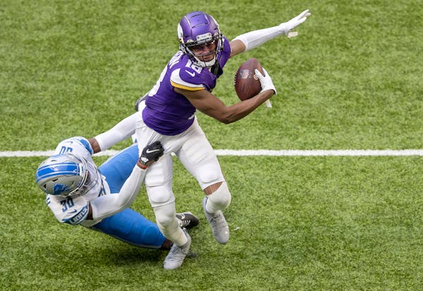 Minnesota Vikings receiver Justin Jefferson (18) tackled by Detroit Lions Jeff Okudah (30) during a reception in the first quarter.