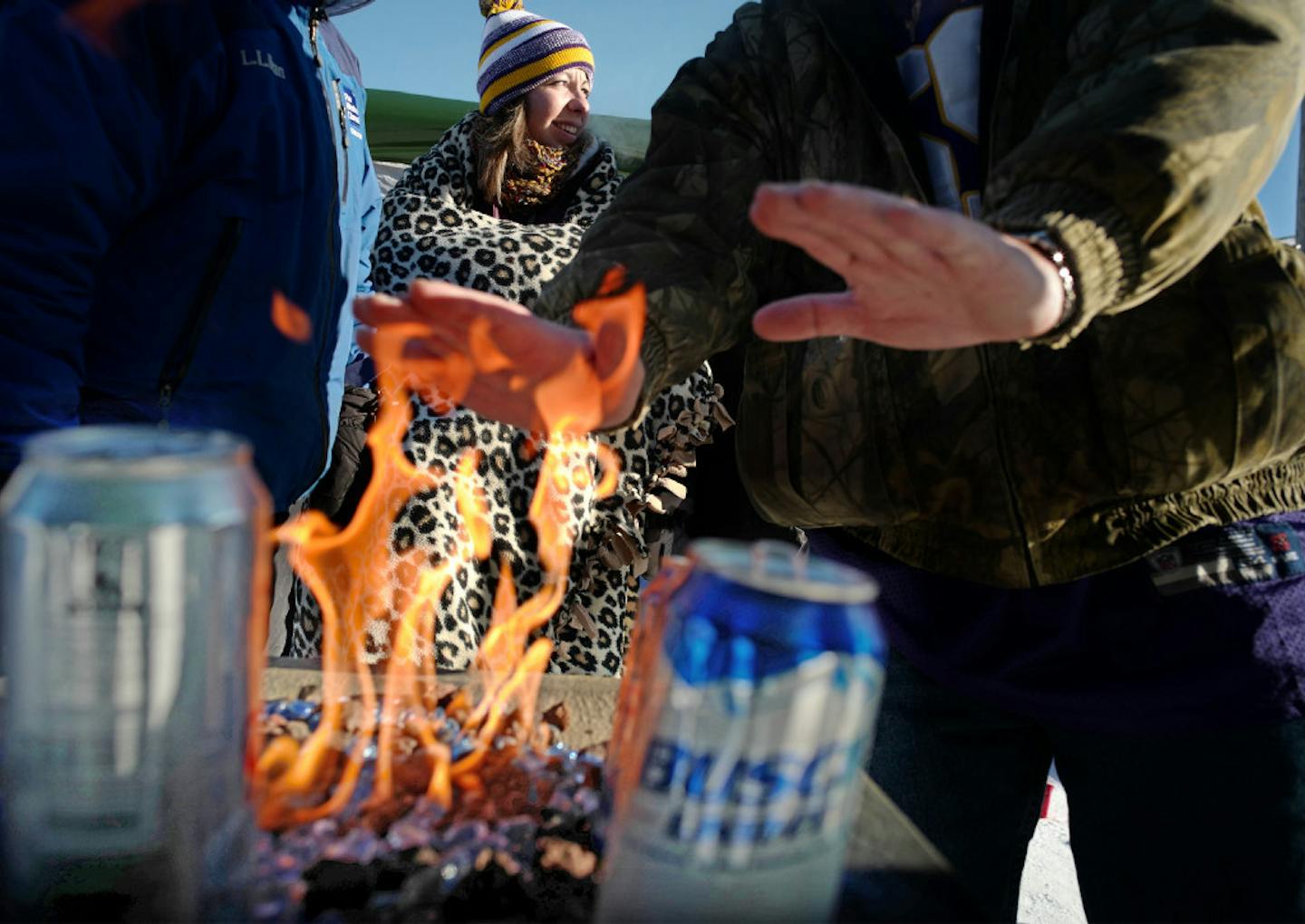 Amanda Zeirden had a blanket to keep her warm as fellow tailgaters kept beers on flames to keep them from freezing. Fans are tailgating near U.S. Bank Stadium in temperatures hovering around -13F before Sunday's game between the Vikings and the Indianapolis Colts.