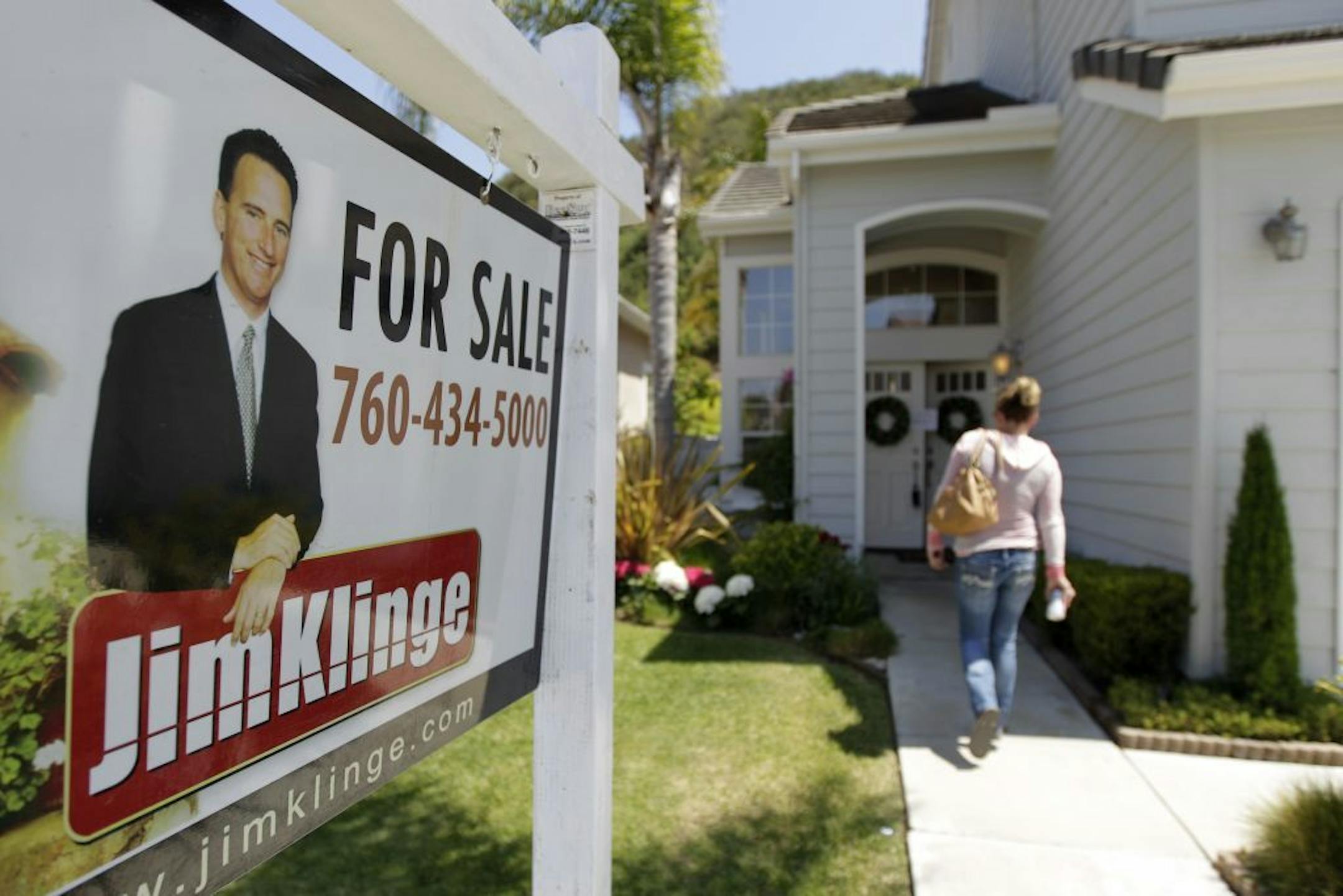 FILE- In this June 13, 2012, file photo, a woman walks to an open house in San Diego. Fixed U.S. mortgage rates fell again to new record lows, providing prospective buyers with even more incentive to brave a modestly recovering housing market. Mortgage buyer Freddie Mac said Thursday, July 5, 2012, that the average on the 30-year loan dropped to 3.62 percent. That's down from 3.66 percent last week and the lowest since long-term mortgages began in the 1950s.