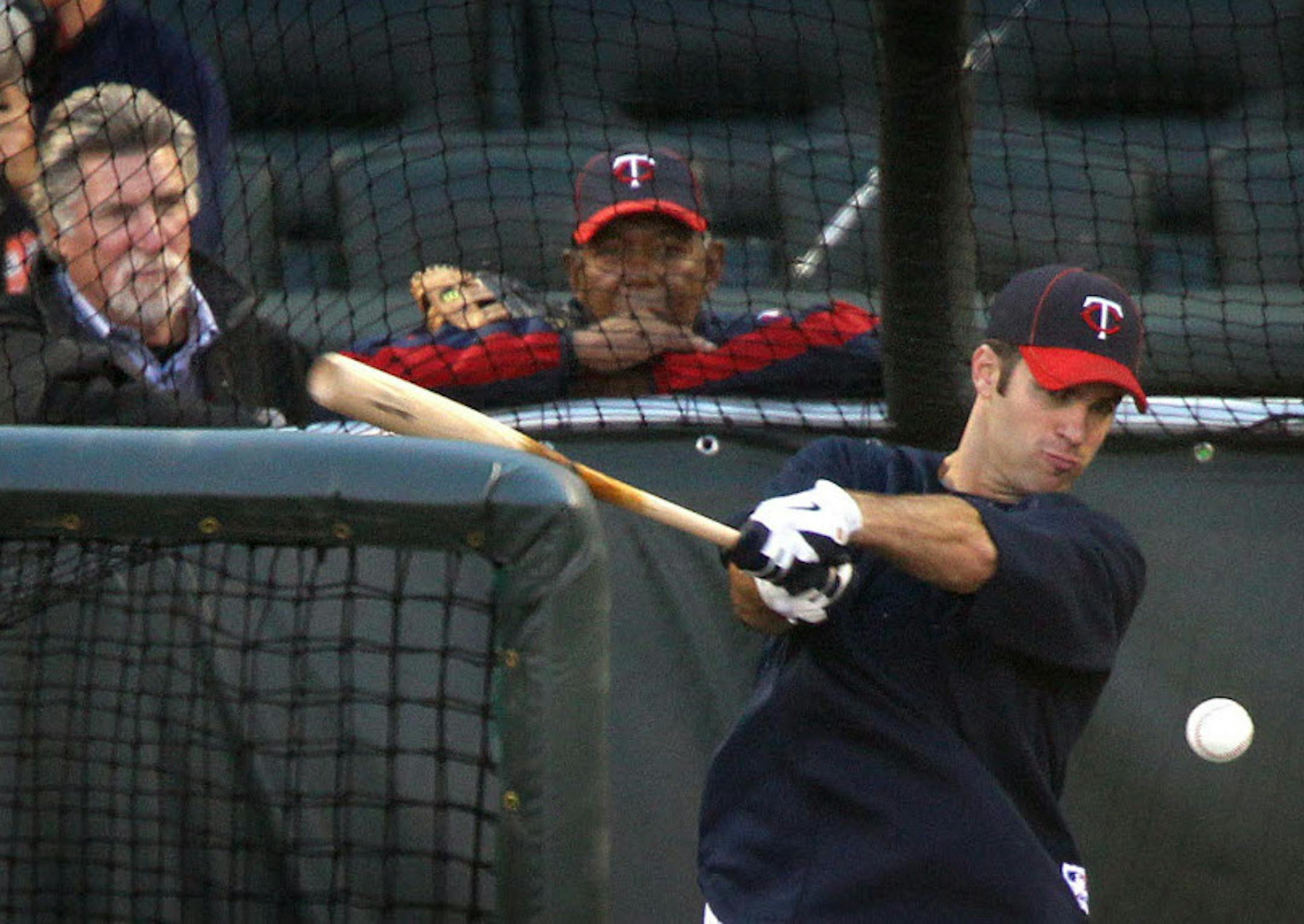 Former Twins greats Jack Morris, left, and Tony Oliva watch Joe Mauer take batting practice