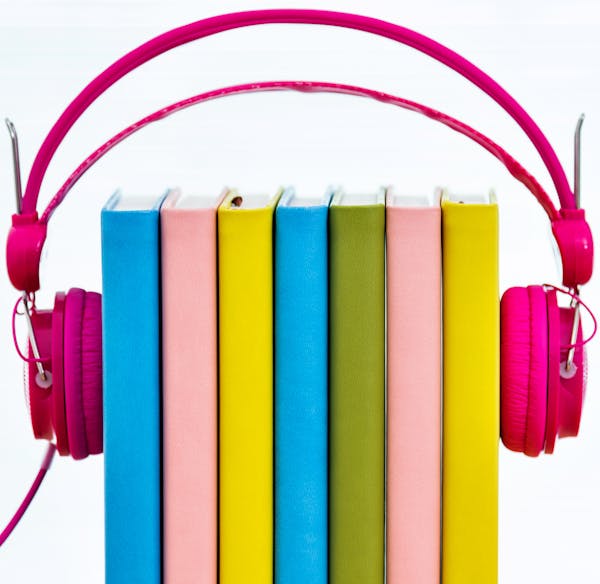 Group of books in headphones, isolated on white background. istock