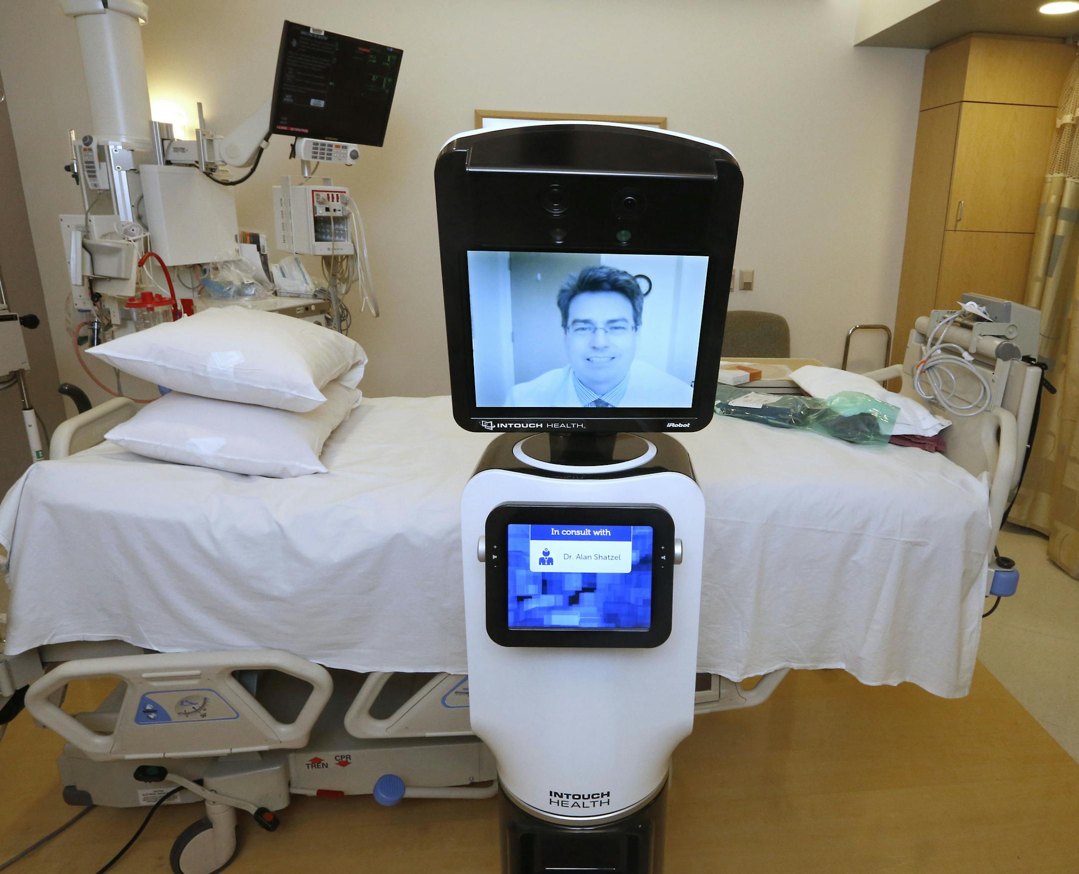In this photo taken Wednesday, Nov. 6, 2013, Dr. Alan Shatzel, medical director of the Mercy Telehealth Network, is displayed on the monitor RP-VITA robot at Mercy San Juan Hospital in Carmichael, Calif. The robots enable physicians to have a different bedside presence as they "beam" themselves into hospitals to diagnose patients and offer medical advice during emergencies. (AP Photo/Rich Pedroncelli)