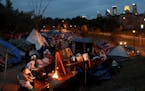 Homeless residents of a large homeless encampment stay warm by a fire Thursday, Oct. 4, 2018, in Minneapolis, MN.