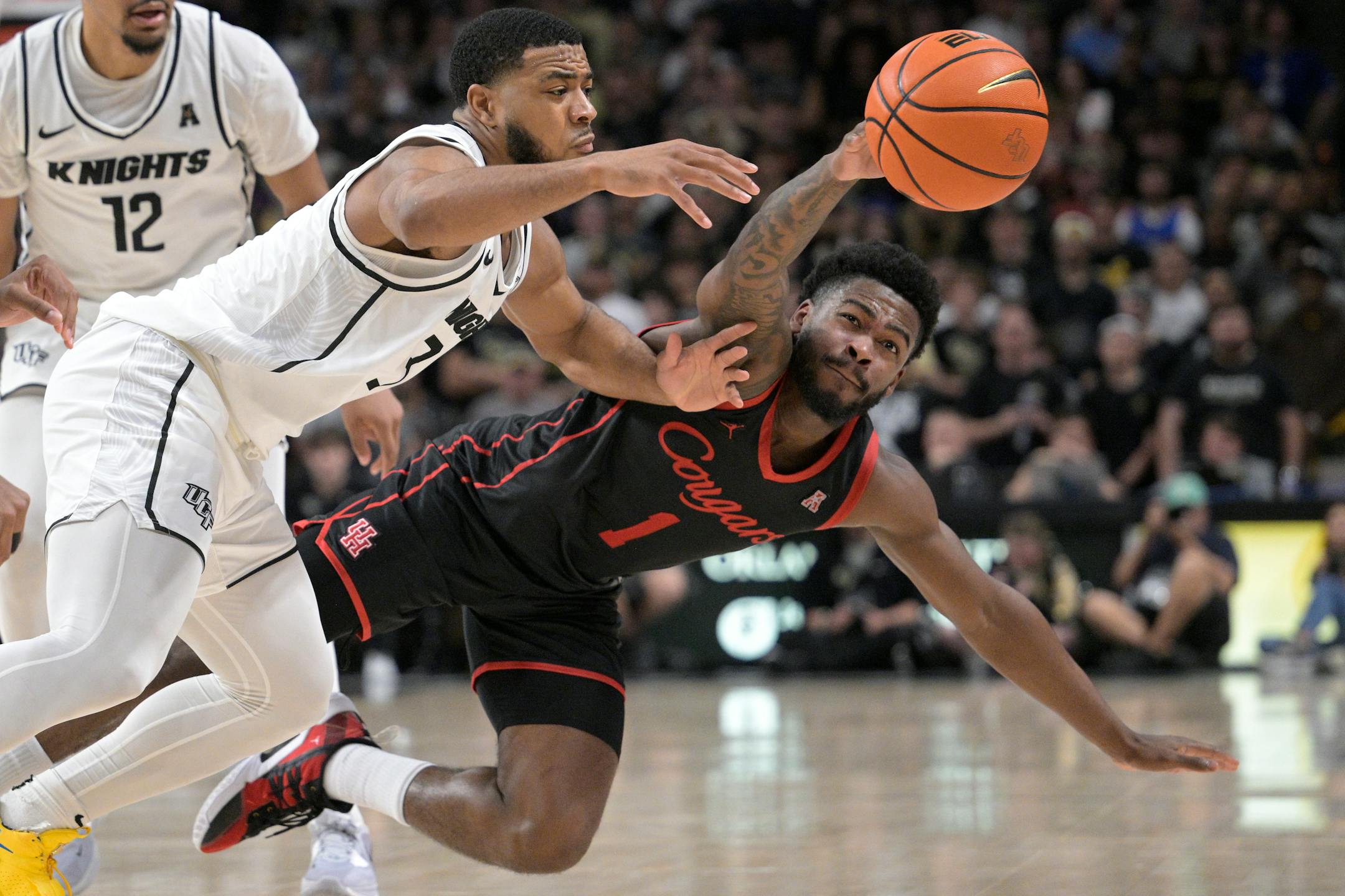 Central Florida guard Darius Johnson and Houston guard Jamal Shead compete for a loose ball during the second half