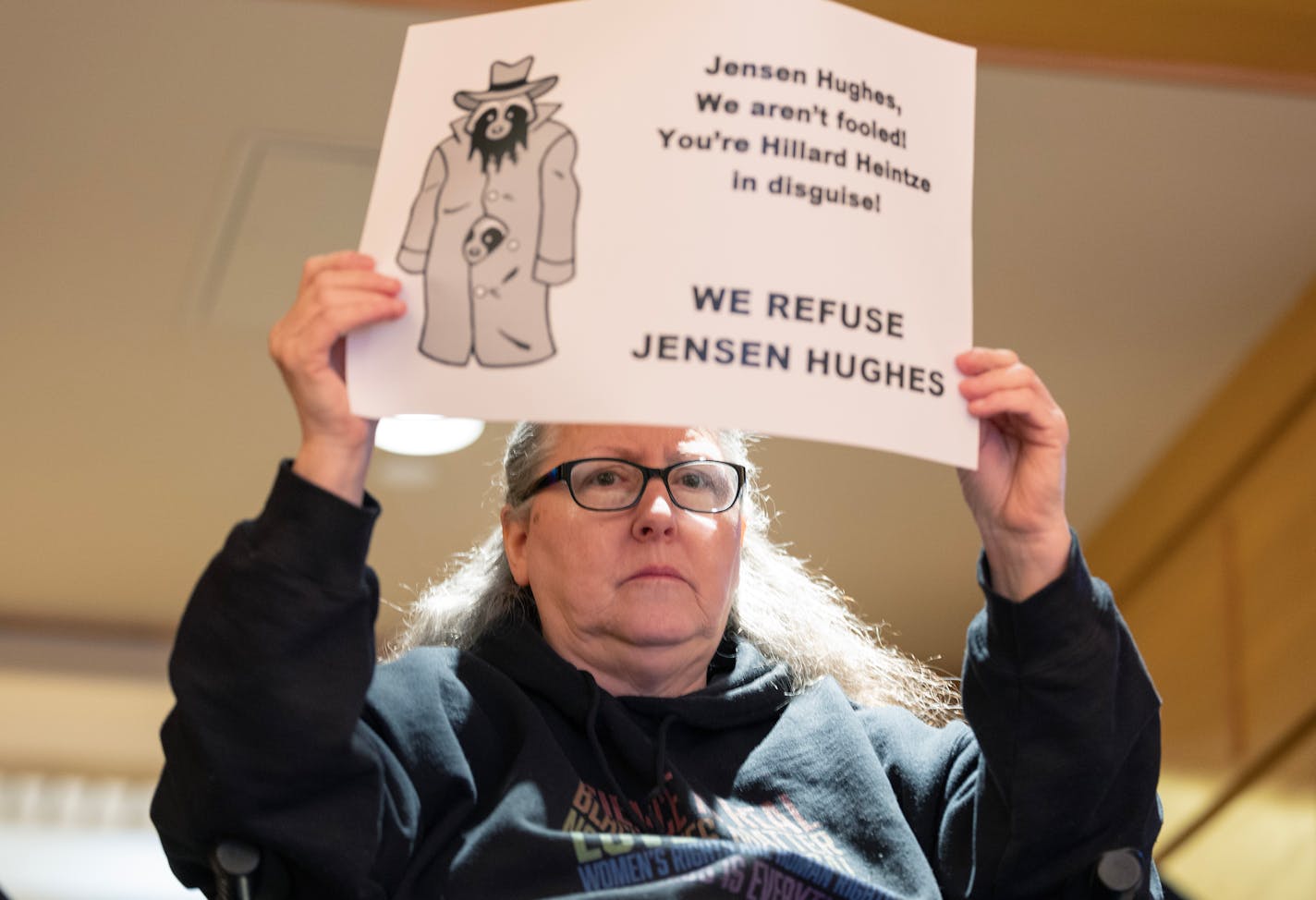 Michelle Gross, President of Communities United Against Police Brutality held up a sign during a presentation Tuesday, January 9, 2024, at Humphrey School of Public Affairs at the University of Minnesota in Minneapolis, Minn. Representatives from Effective Law Enforcement for All spoke as Representatives from Effective Law Enforcement for All, Jensen Hughes and Relman Colfax made their presentations for Minneapolis' new independent evaluator. ] CARLOS GONZALEZ • carlos.gonzalez@startribune.com