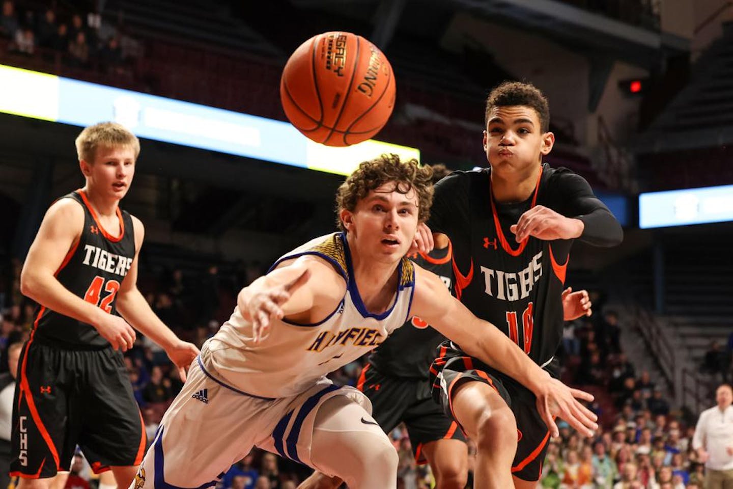 Hayfield's Easton Fritcher (4) reaches for a loose ball at the baseline along side Cherry's Isaiah Asuma (10). Fritcher tallied 16 points and 12 rebounds on Friday afternoon. Photo by Cheryl A. Myers, SportsEngine